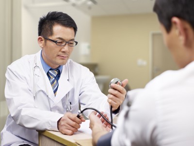 asian doctor measuring blood pressure of a patient.