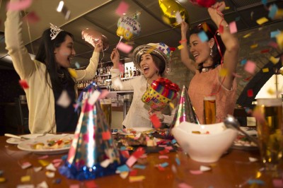 Three women in the confetti, celebrating the birthday