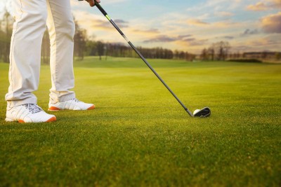 Golf ball on grass in front of golf club